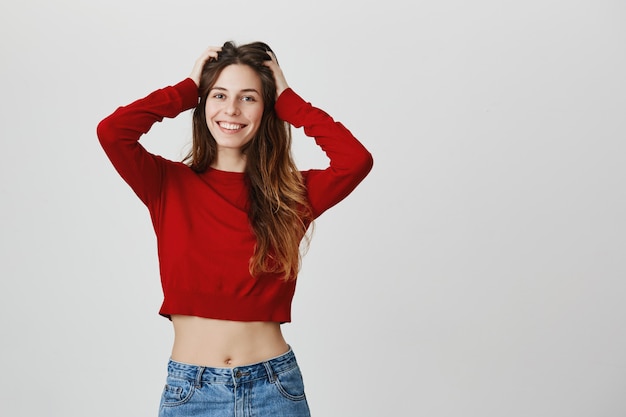 Smiling happy woman in cropped sweater tousle hair