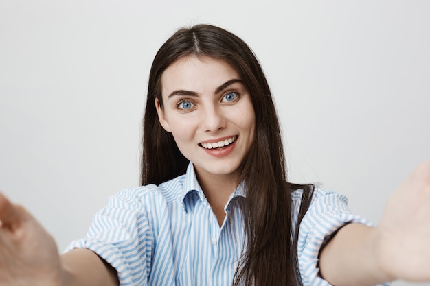 Donna felice sorridente che cattura selfie o videochatting