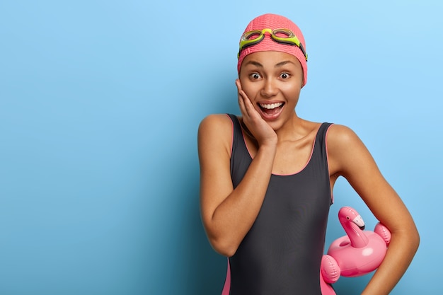 Smiling happy woman wears swimming costume and rubber swimcap