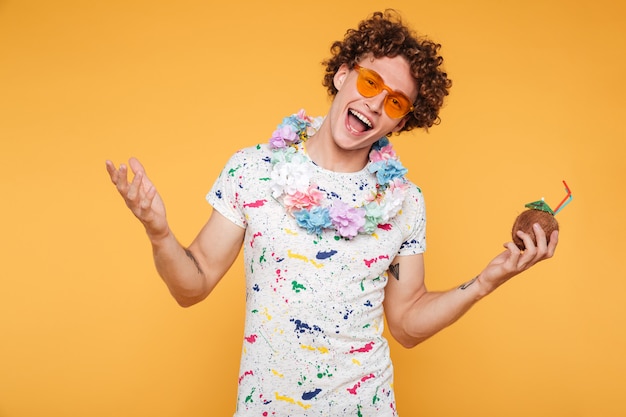 Улыбающийся счастливый молодой человек в солнцезащитных очках и пляжной одежде