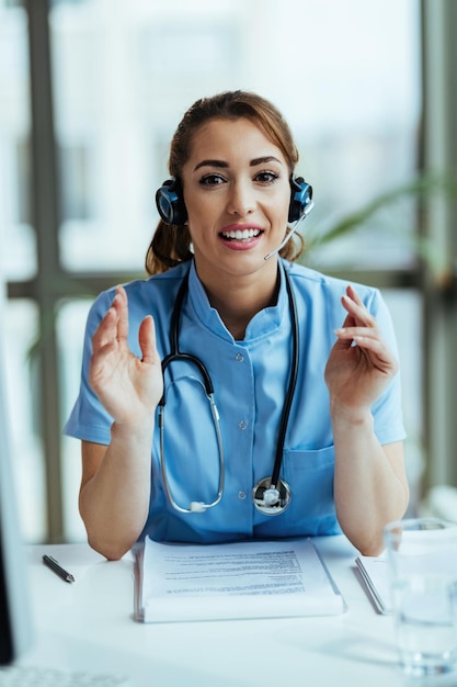 Foto gratuita operatore sanitario sorridente con auricolare che lavora al call center dell'ospedale e guarda la fotocamera