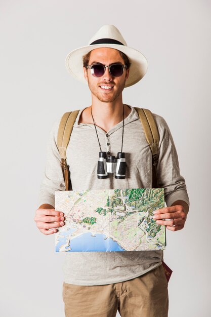 Smiling hipster traveler holding map