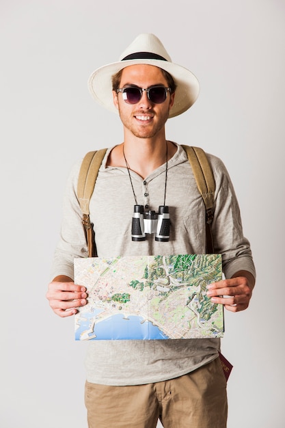 Smiling hipster traveler holding map