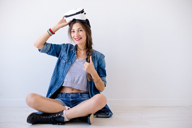 Улыбающаяся хипстерская женщина измеряет очки VR