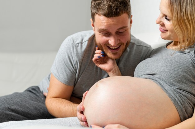 Pancia incinta commovente sorridente della moglie del marito