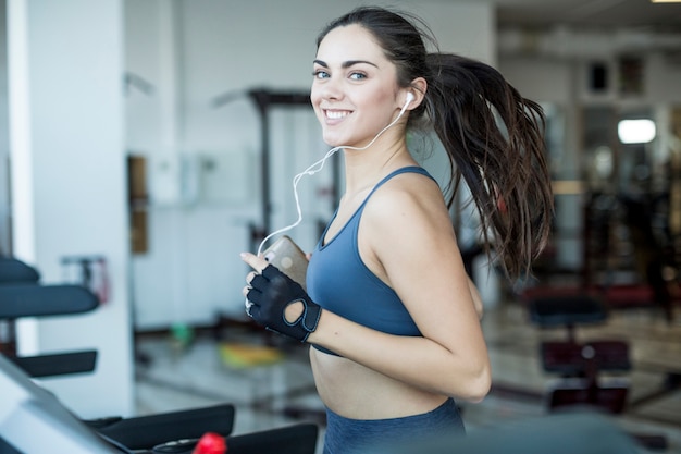 Donna pareggiante sorridente che ascolta la musica