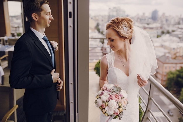 Free photo smiling just-married couple on balcony