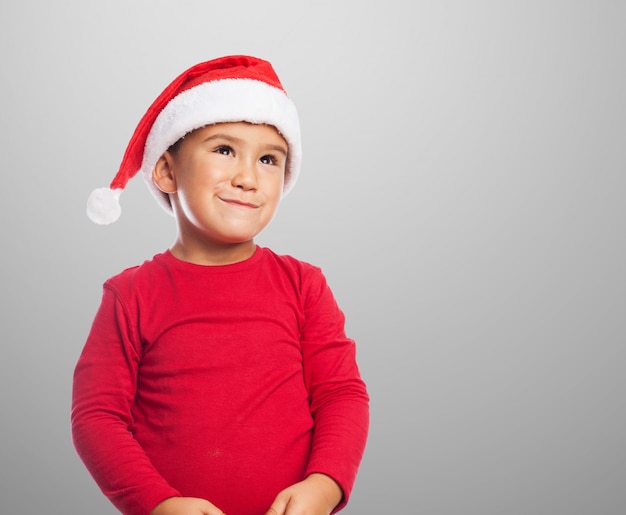 Улыбаясь мальчик носить шляпу Санта