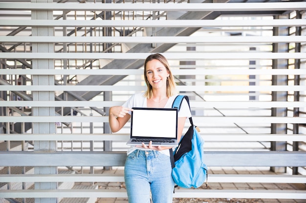 Foto gratuita signora sorridente che indica allo schermo del computer portatile