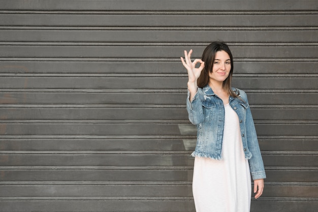 Free photo smiling lady with ok gestures