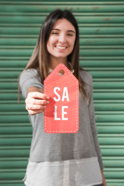 Free photo smiling lady with sale tag