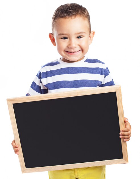 Smiling little boy holding a blackboard