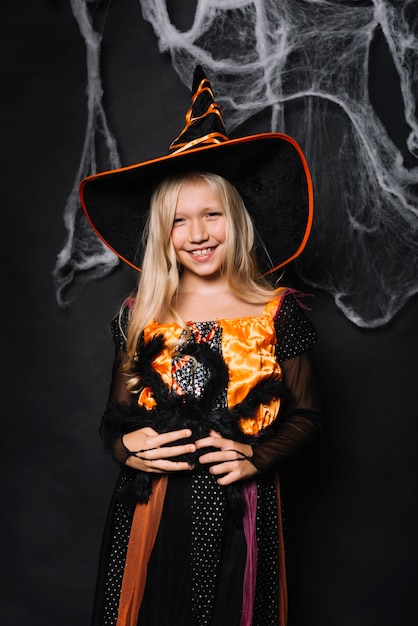 Smiling little girl holding big toy spider