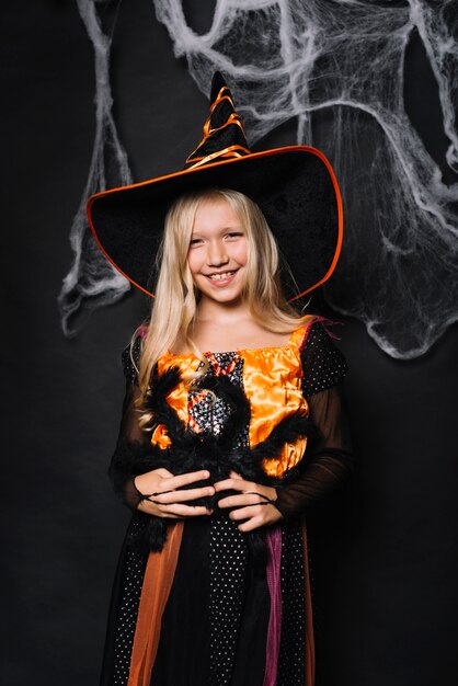 Smiling little girl holding big toy spider