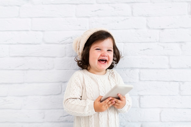 Smiling little girl holding a phone