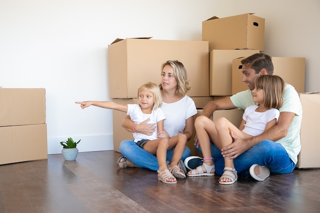 Smiling little girls sitting on parents legs