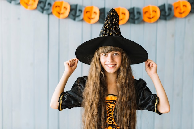Улыбающаяся маленькая ведьма на вечеринке Хэллоуина