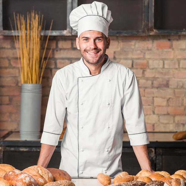 Smiling male baker with freshly baked breads