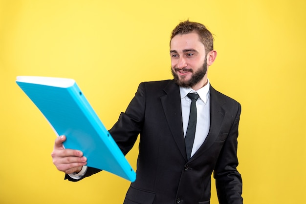 Free photo smiling male executive reading his successful project with pride on yelow