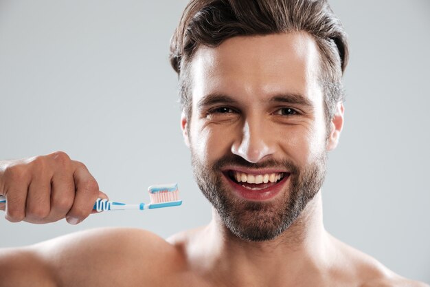 Улыбающийся человек чистит зубы