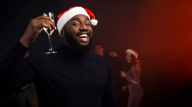 Smiling man cheering with champagne glass for new years