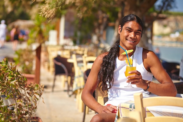 Smiling man drinking an orange juice