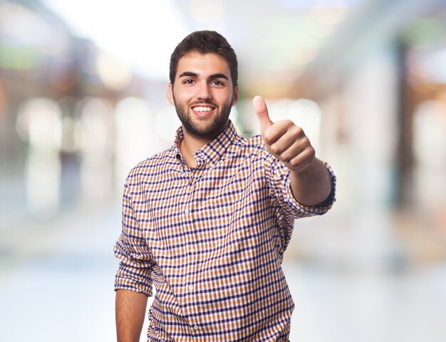 Smiling man gesturing thumb up. 