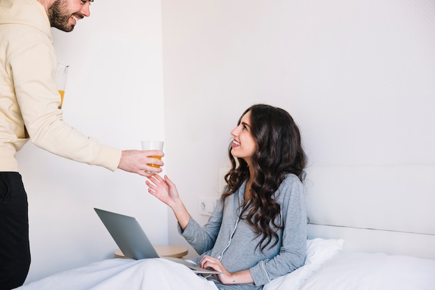 Free photo smiling man giving juice to girlfriend