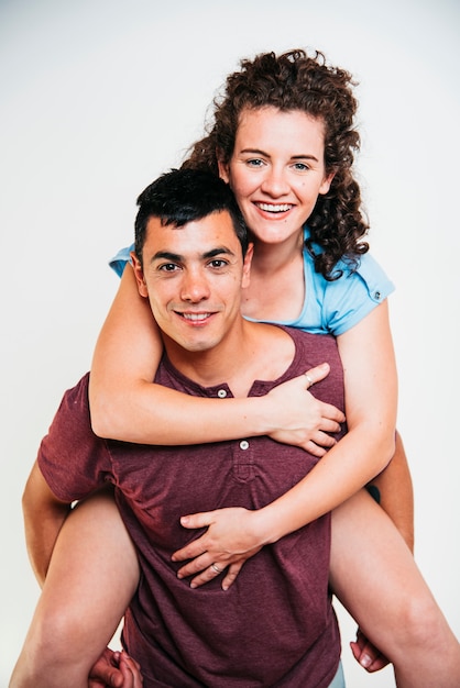 Smiling man holding on back young woman