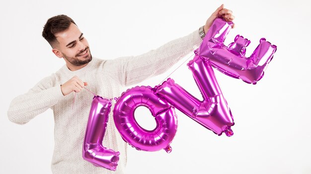 Smiling man holding balloon love writing