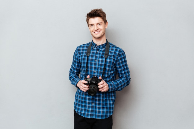 Smiling man holding camera in hands