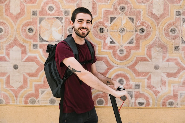 Smiling man holding e-scooter handles