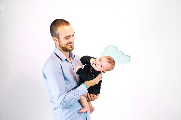 Smiling man holding funny child