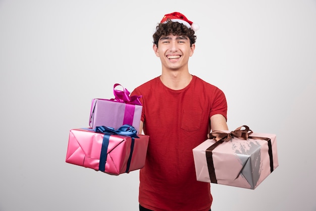 Uomo sorridente che tiene i suoi regali di natale.