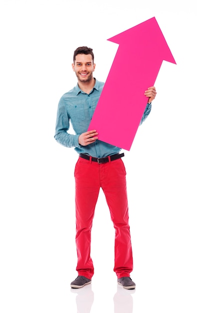 Smiling man holding pink sign of arrow