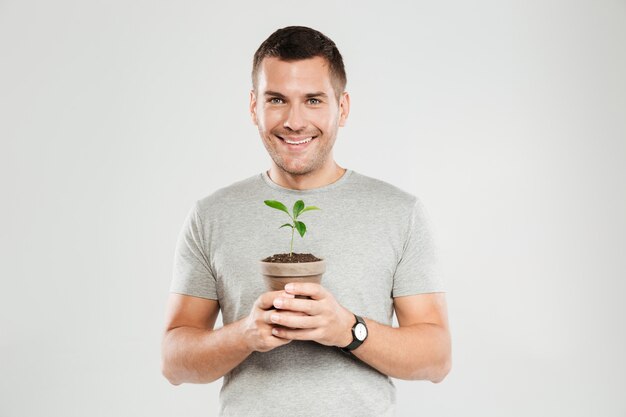 Smiling man holding plant.