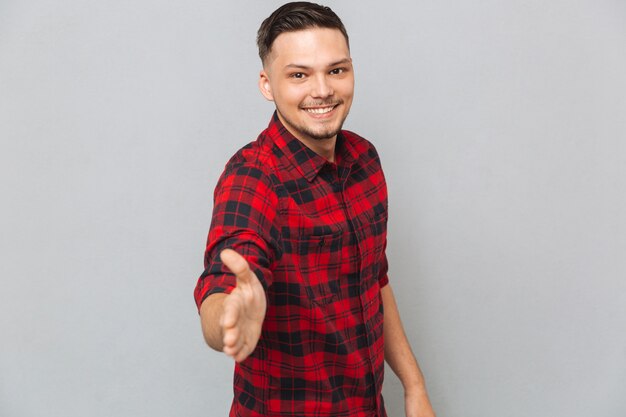 Smiling man holds out his hand for a handshake