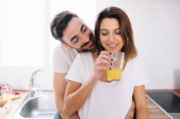 Smiling man hugging woman with juice