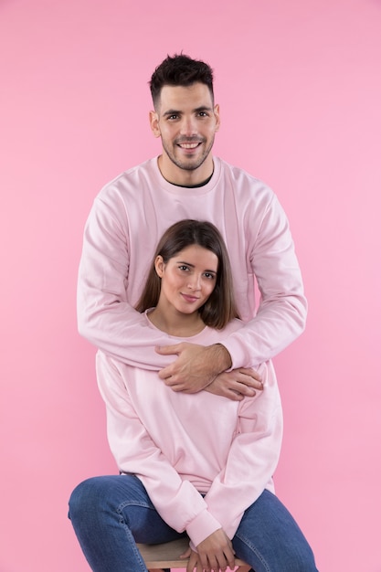 Smiling man hugging young woman on stool