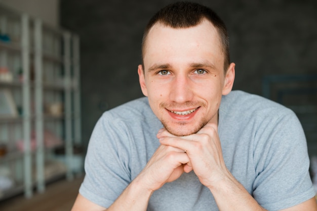 Free photo smiling man leaning on fist and looking at camera