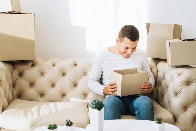 Smiling man looking in cardboard box