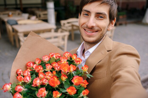 꽃으로 selfie를 만드는 웃는 남자