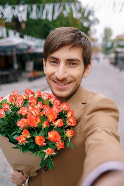 花とselfieを作る笑みを浮かべて男