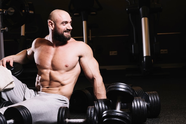 Smiling man near dumbbells