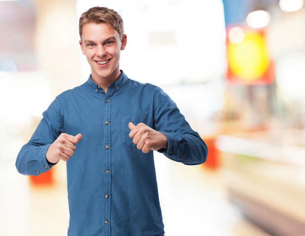 Free photo smiling man pointing at himself with his thumbs