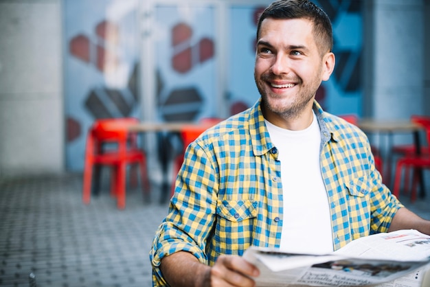 Free photo smiling man posing with newspaper