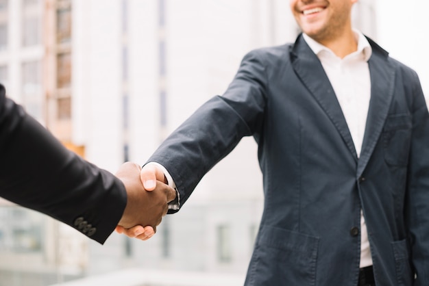 Smiling man shaking hand of colleague