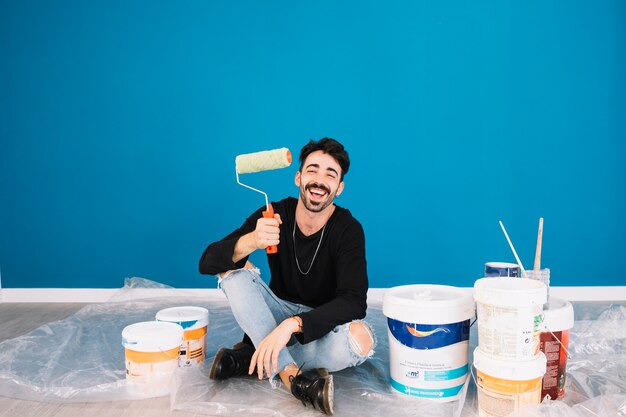 Smiling man showing paint roll