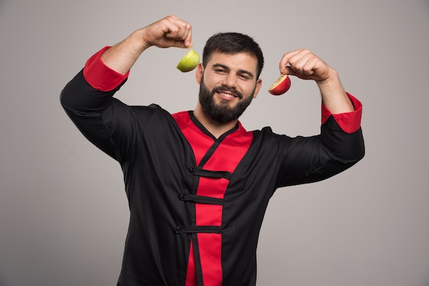 Smiling man showing a slices of fresh apple .