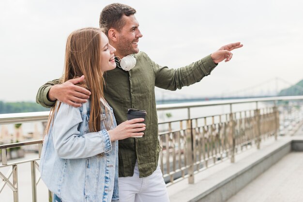 Smiling man showing something to his girlfriend